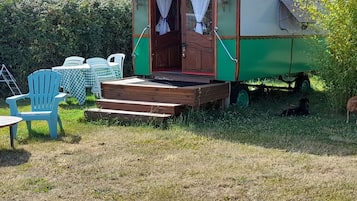 Een oldtimer camper met een houten dek en een groene buitenkant.