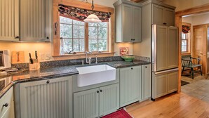 Una cocina con una isla grande, un lavamanos doble y un refrigerador.