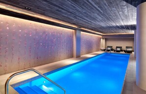 A modern indoor swimming pool with a clear blue water surface, a wooden ceiling, and a wall with a floral pattern. - Nobu Hotel Chicago (Chicago)