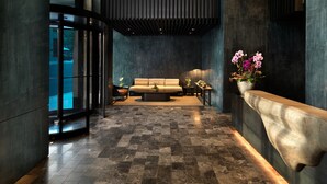 A modern lobby with a sofa, a coffee table, and a vase of flowers. - Nobu Hotel Chicago (Chicago)