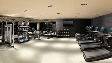 A modern gym with treadmills, weight machines, and exercise balls.
