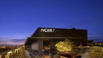 A modern building with the name "NOBU" illuminated on the facade.
