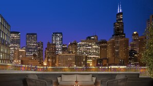 A rooftop terrace with a view of a city skyline at dusk. - Nobu Hotel Chicago (Chicago)
