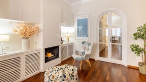 Un salon moderne avec une cheminée, un fauteuil confortable et une plante en pot.