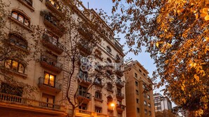 Un immeuble à plusieurs étages doté de balcons, d’un commerce au rez-de-chaussée et d’une zone piétonne.
