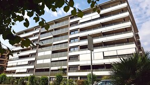 A multi-story building with a modern architectural design, featuring balconies on each floor.