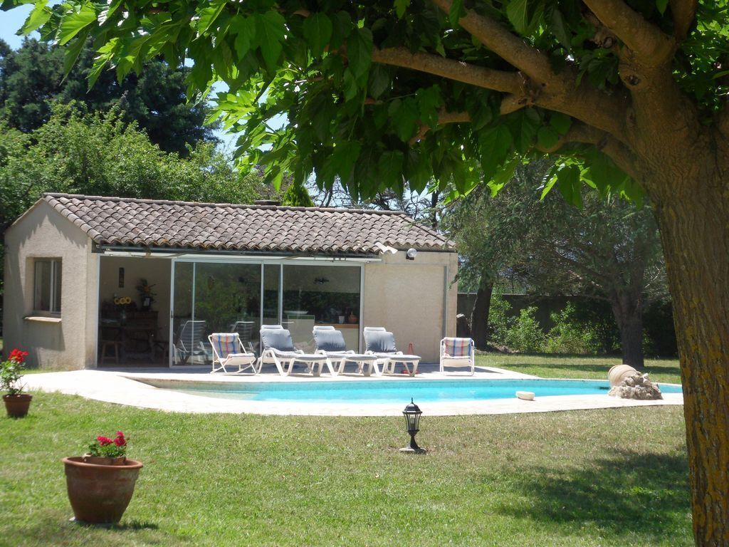 A house with a swimming pool, a covered patio, and outdoor seating.