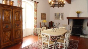 Un comedor con un aparador de madera, una araña y una chimenea.