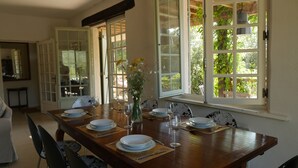 Comedor con una mesa de madera dispuesta para cuatro personas, rodeado de sillas.