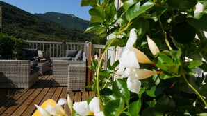 Terraza con mobiliario de mimbre y vistas a las montañas.