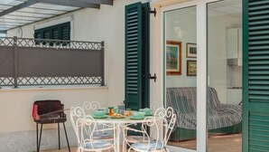 A patio with a table and chairs, a piano, and a sofa. - Michelangelo I by Interhome (Marina Pietrasanta)