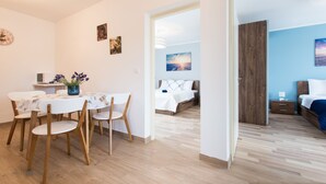 A modern room with a dining area, a bed, and a wooden wardrobe. - Apartman Tonci (Primosten)
