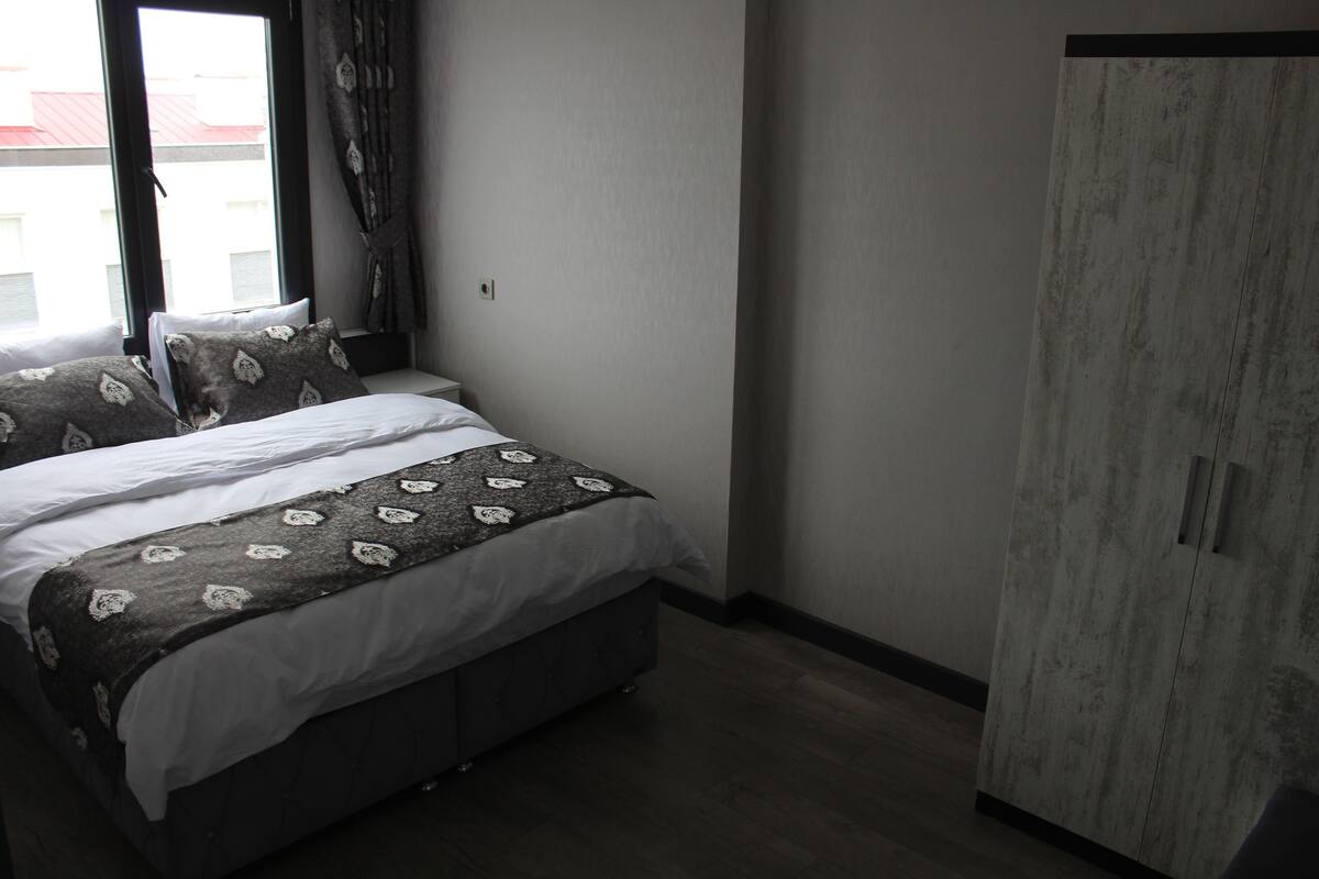 Ein Schlafzimmer mit einem Bett, einem Kleiderschrank und einem Fenster.