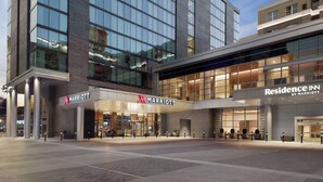 Un hotel Marriott con una fachada moderna, grandes ventanales y un área de entrada bien iluminada.
