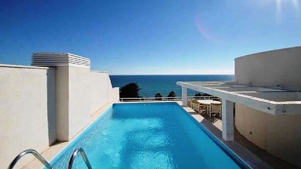 Une piscine sur le toit offrant une vue dégagée sur l’océan.