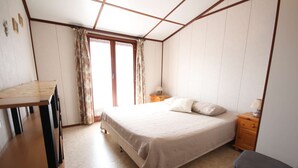A bedroom with a bed, a desk, a chair, and a nightstand. - Villa located in Tamaris, 3 bedrooms, half Airco, Wifi, for 7 people, only at 400m from the beach... (PORTIRAGNES)