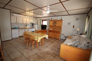 Um espaço de estar compacto com cozinha, área de refeições e sofá.