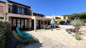 A courtyard with outdoor seating, a pool, and a building with a tiled roof. - VILLA  in the résidence TAMARIS, 4 bedrooms, Wifi, Airco in living room, in PORTIRAGNES PLAGE (PORTIRAGNES)