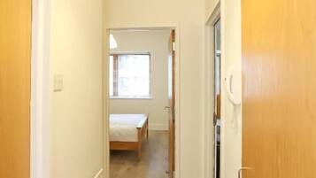 A narrow hallway with wooden doors and a radiator on the left.