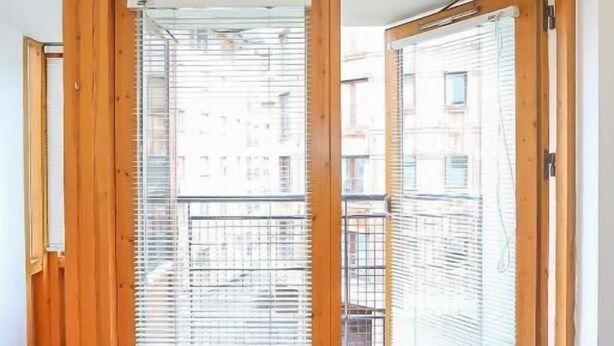A room with a large sliding wooden door leading to a balcony. - IFSC Townhouse Apartments (Dublin)