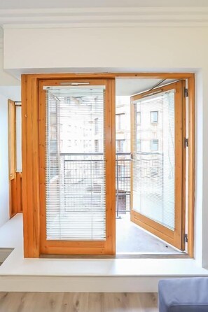 Quarto com uma grande porta de madeira deslizante que dá para uma varanda.