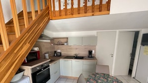A compact kitchen with a washing machine, a coffee maker, and a microwave. - Nice renovated Holiday house for 5 people, in a secured residence with pool (mid june/mid sept),... (PORTIRAGNES)