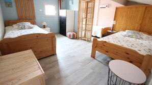A bedroom with two wooden beds, a small round table, a wardrobe, and a window. - Nice renovated Holiday house for 5 people, in a secured residence with pool (mid june/mid sept),... (PORTIRAGNES)
