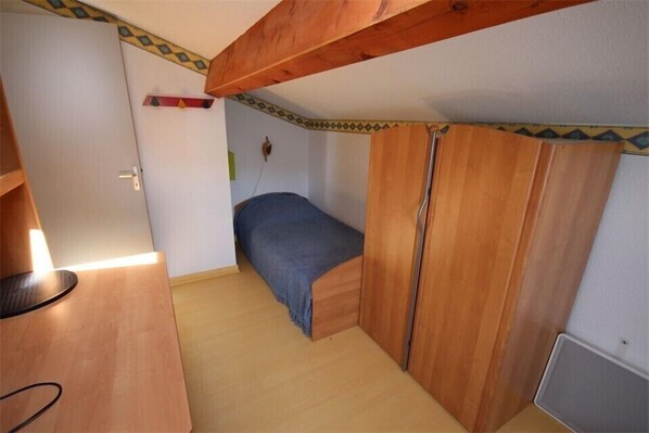 A compact bedroom with a single bed, wooden wardrobe, and a small desk with a chair. - Nice holiday house with 2 bedrooms, 5 people, in a secured residence with commun pool, 200m from... (PORTIRAGNES)