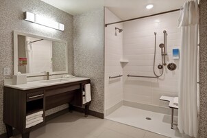 Un baño moderno con ducha, lavamanos y tocador.