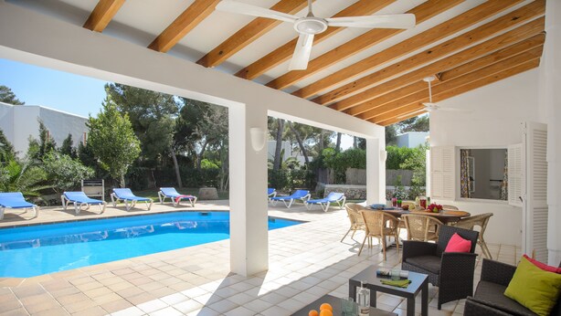 Area piscina esterna con sedie a sdraio e un tavolo da pranzo.