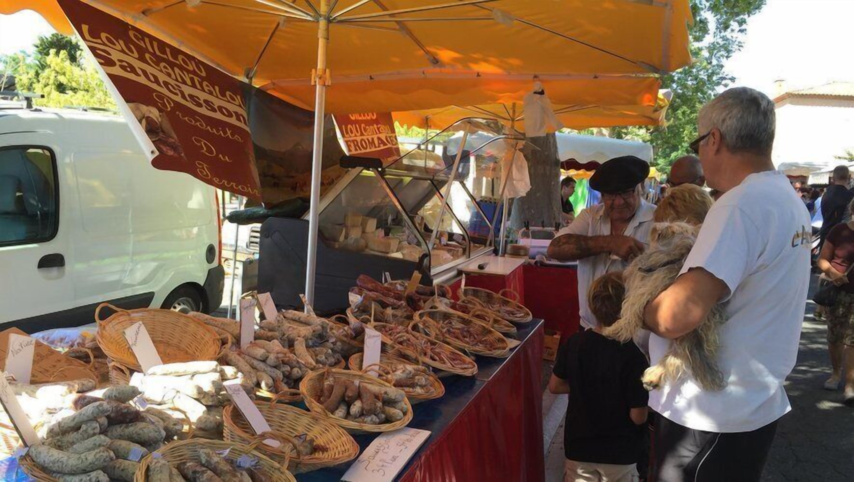 A market stall with various food items displayed in baskets under a canopy.