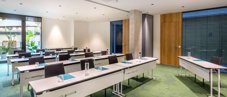 A conference room with long tables, chairs, and a projector.
