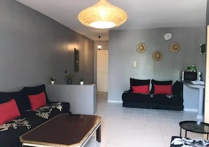 Relax in this stylish living room with a sofa, armchair, and coffee table, perfect for unwinding.
