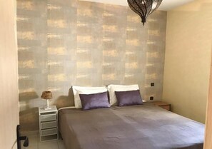 Restful retreat with a large bed, bedside table, and lamp.
