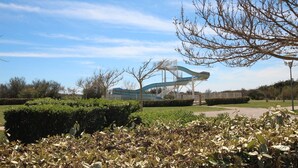 A park with a water slide structure, well-maintained bushes, and a clear sky. - Nice villa in residence CLOS DE SOCORRO with pool, 2 bedrooms, great View, PORTIRAGNES PLAGE (PORTIRAGNES)