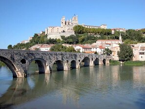A stone bridge over a river with a historic building on a hill in the background. - Spacious corner villa with nice view on natural reserve, 3 bedrooms, AIRCO, PORTIRAGNES PLAGE (PORTIRAGNES)