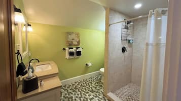 Une salle de bain avec un lavabo, des toilettes et une douche.