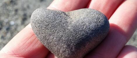 A heart-shaped stone held in a hand.