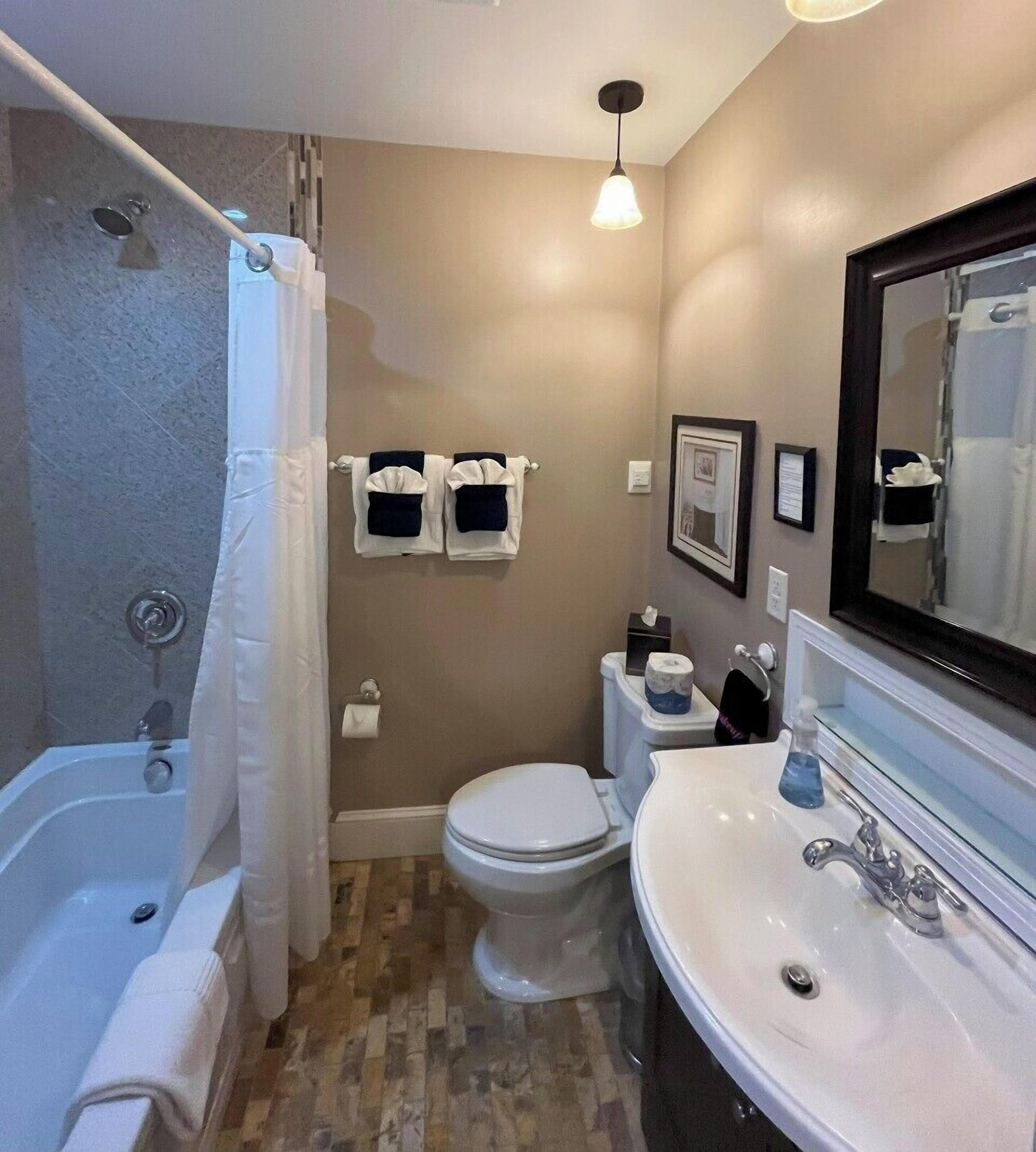 A bathroom with a bathtub, toilet, and sink.