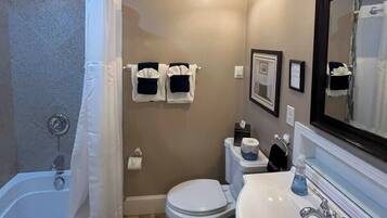 A bathroom with a bathtub, toilet, and sink.
