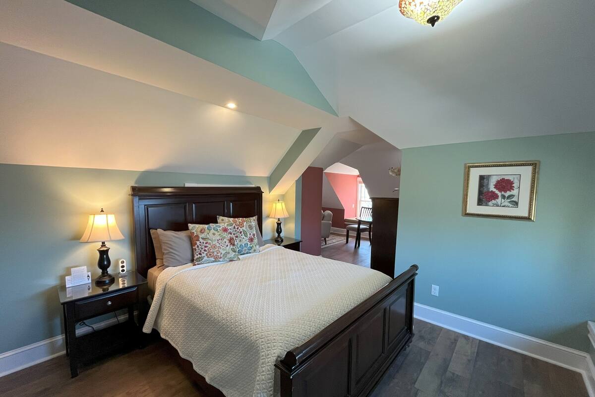 A bedroom with a bed, nightstands, a lamp, and a picture on the wall.