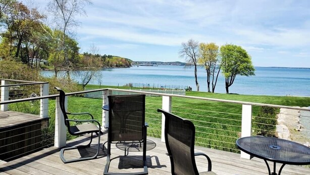 Una terraza con muebles de exterior con vista a un lago.