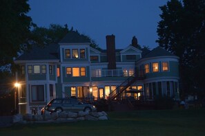 A large, multi-story house with a prominent chimney, multiple windows, and a staircase leading to a balcony. - Saltair Inn Waterfront B&B (Bar Harbor)