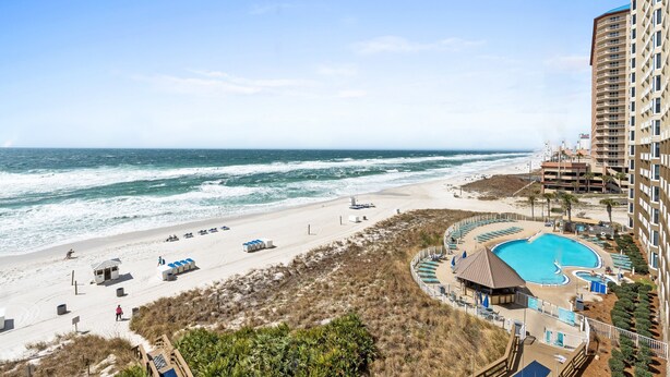 A beachfront hotel with a swimming pool, beach access, and ocean views.