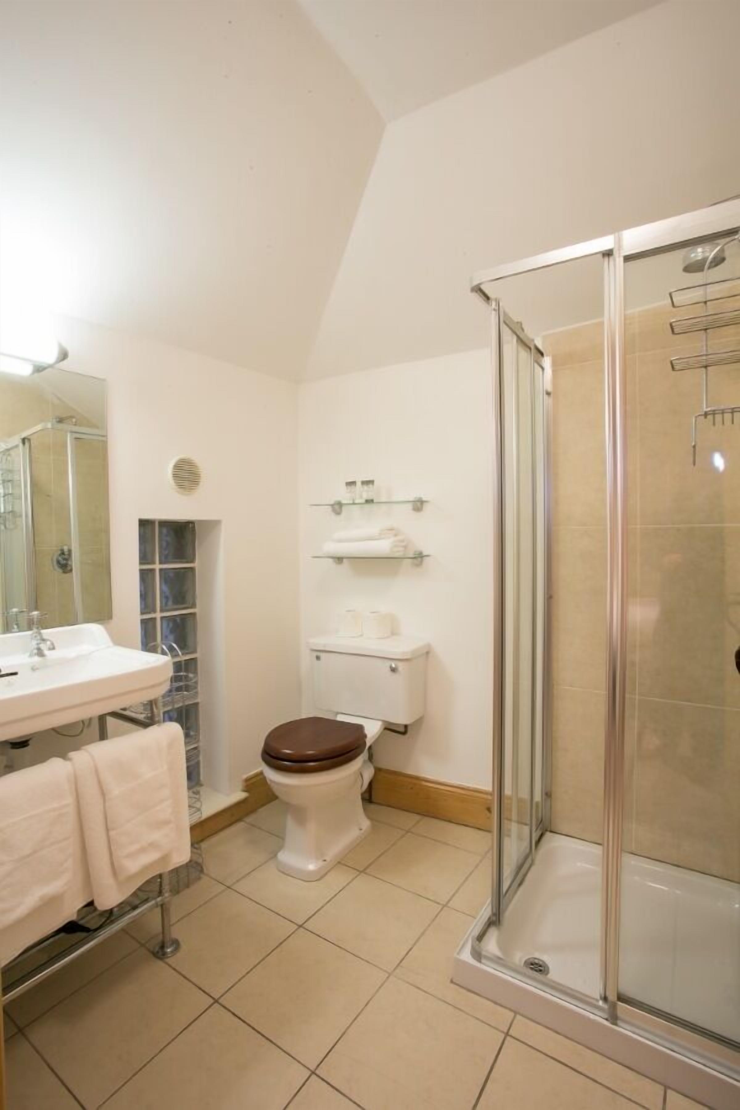 A bathroom with a toilet, sink, and shower.