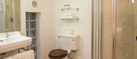 A bathroom with a toilet, sink, and shower.