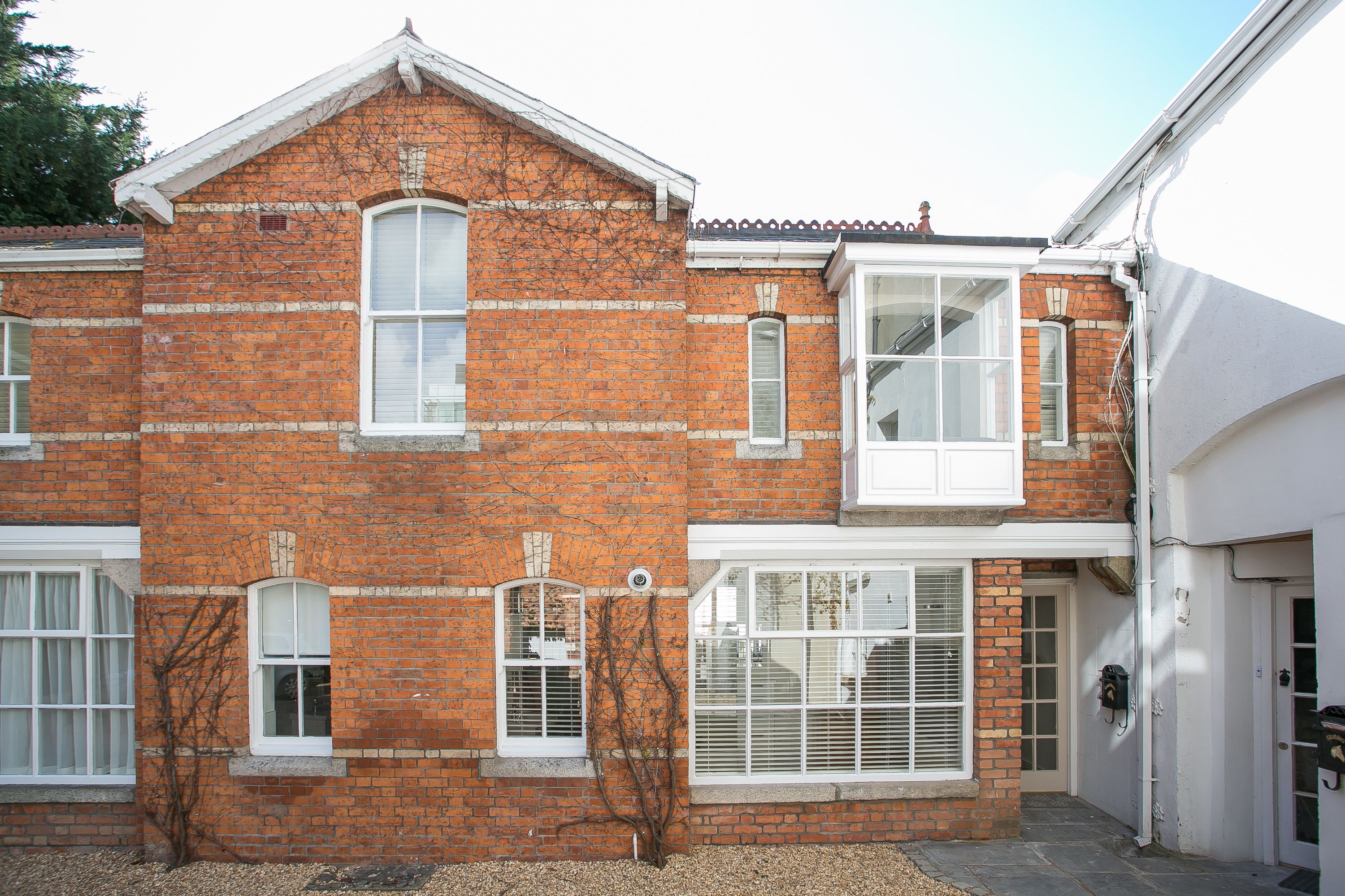 A two-story brick building with white-framed windows and a door.