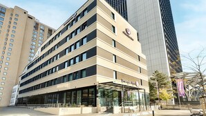 Modernilla designilla varustettu hotelli, jonka huomiota herättävä sisäänkäynti on katetulla alueella, ja jossa on selkeästi näkyvät opasteet.