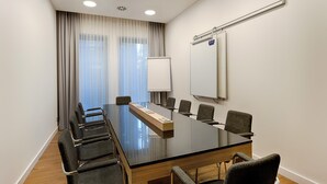 A conference room with a glass table, six chairs, a whiteboard, and a projector screen. - Premier Inn Frankfurt Westend (Frankfurt)
