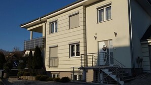 Een modern gebouw met twee verdiepingen, een plat dak, grote ramen en een balkon.